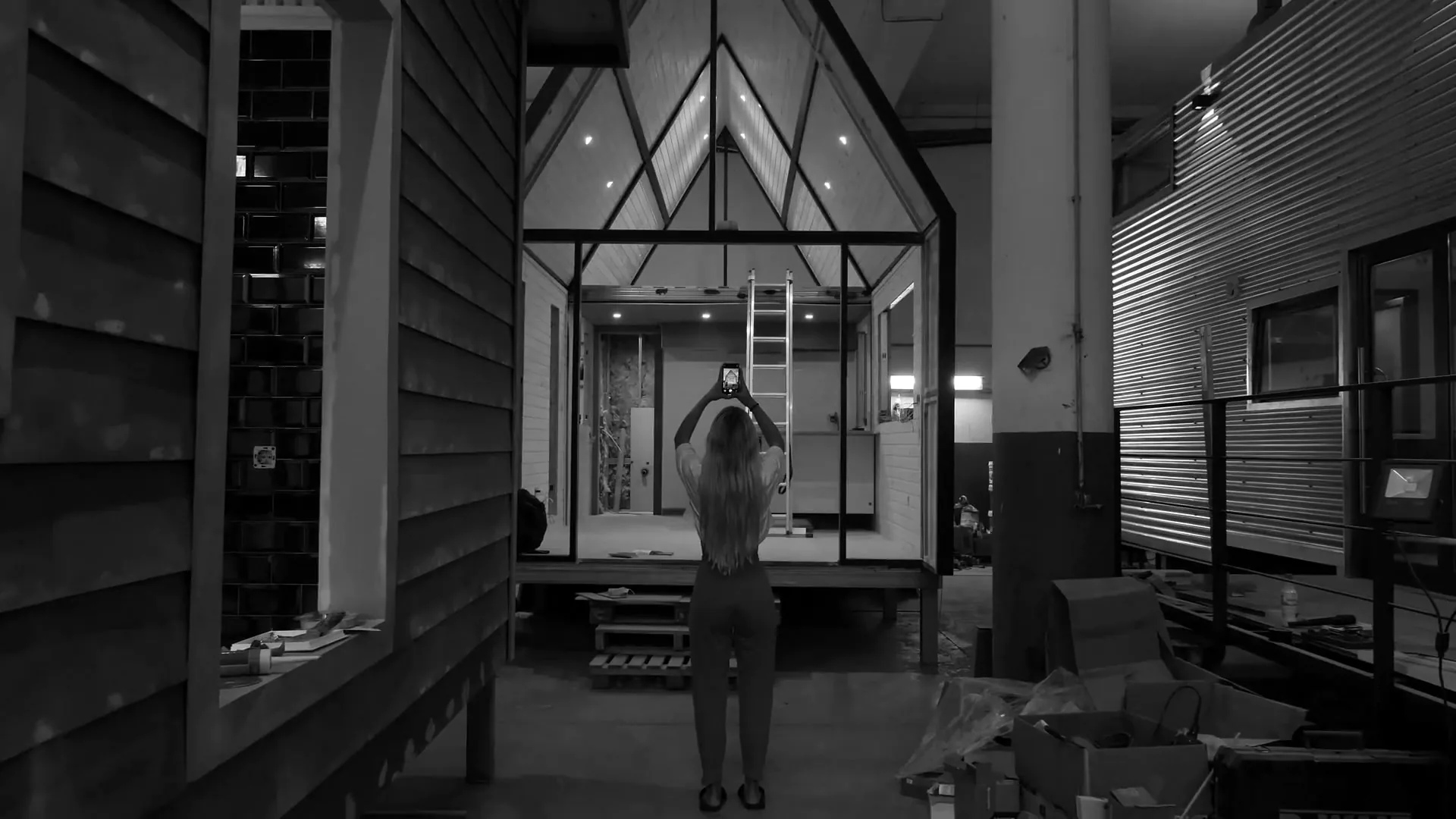 A person uses a phone to photograph a building interior.